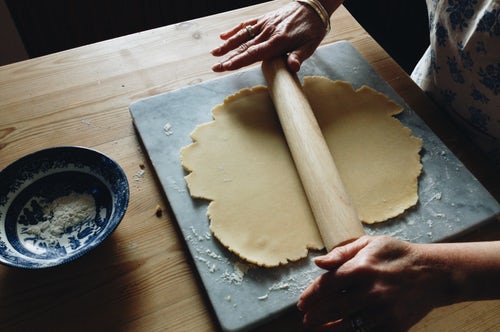 Baker using a rolling pin on pastry