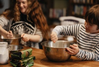 family stirring a pot for baking a cake